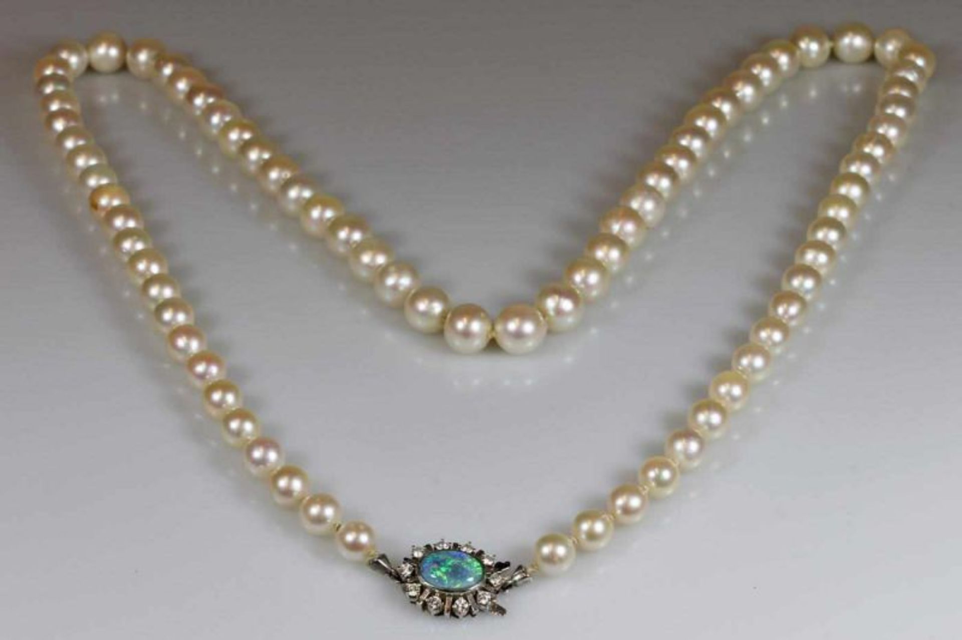 Perlenkette, 77 Akoya-Zuchtperlen ø ca. 8.5 mm, Schließe WG 585, 1 Opal-Cabochon, 10 Brillanten zus.