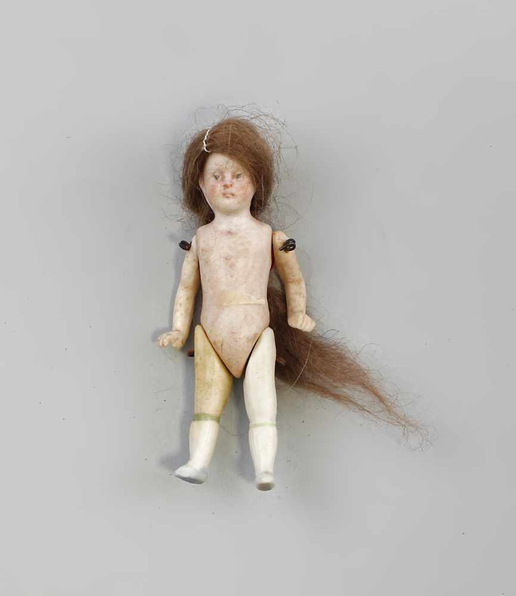 Ganz-Bisk.-Porz.-Puppenstubenpuppe um 1900, braune Perrücke, Arme und Beine mit Draht aufgezogen,