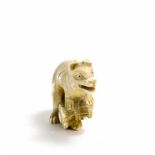 Netsuke 'Hund mit Reuse' Japan, um 1900, Elfebein, geschnitzt, unter dem Fuß mit Signatur, Höhe 3,