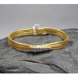 ARMBAND, 750er Gelbgold (28 g), gearbeitet aus geflochtenen und gekreuzten Strängen und besetzt