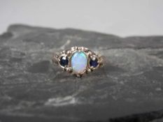 RING, England, 375er Gelbgold (2,9 g) besetzt mit einem Opal, der von zwei Saphiren flankiert ist.