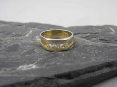 RING, bicolor, 750er Gold (5,4g), Ringschiene besetzt mit 5 Brillangen von je 0,05ct. Ringgr. 56/57.