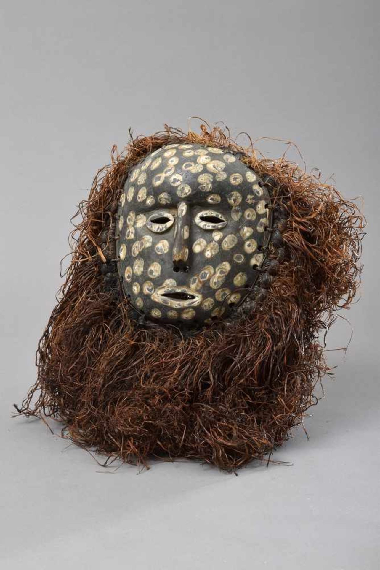 Afrikanische Maske mit Pflanzenfasern, Holz geschnitz, partiell mit weißen Punkten, H. 19cm