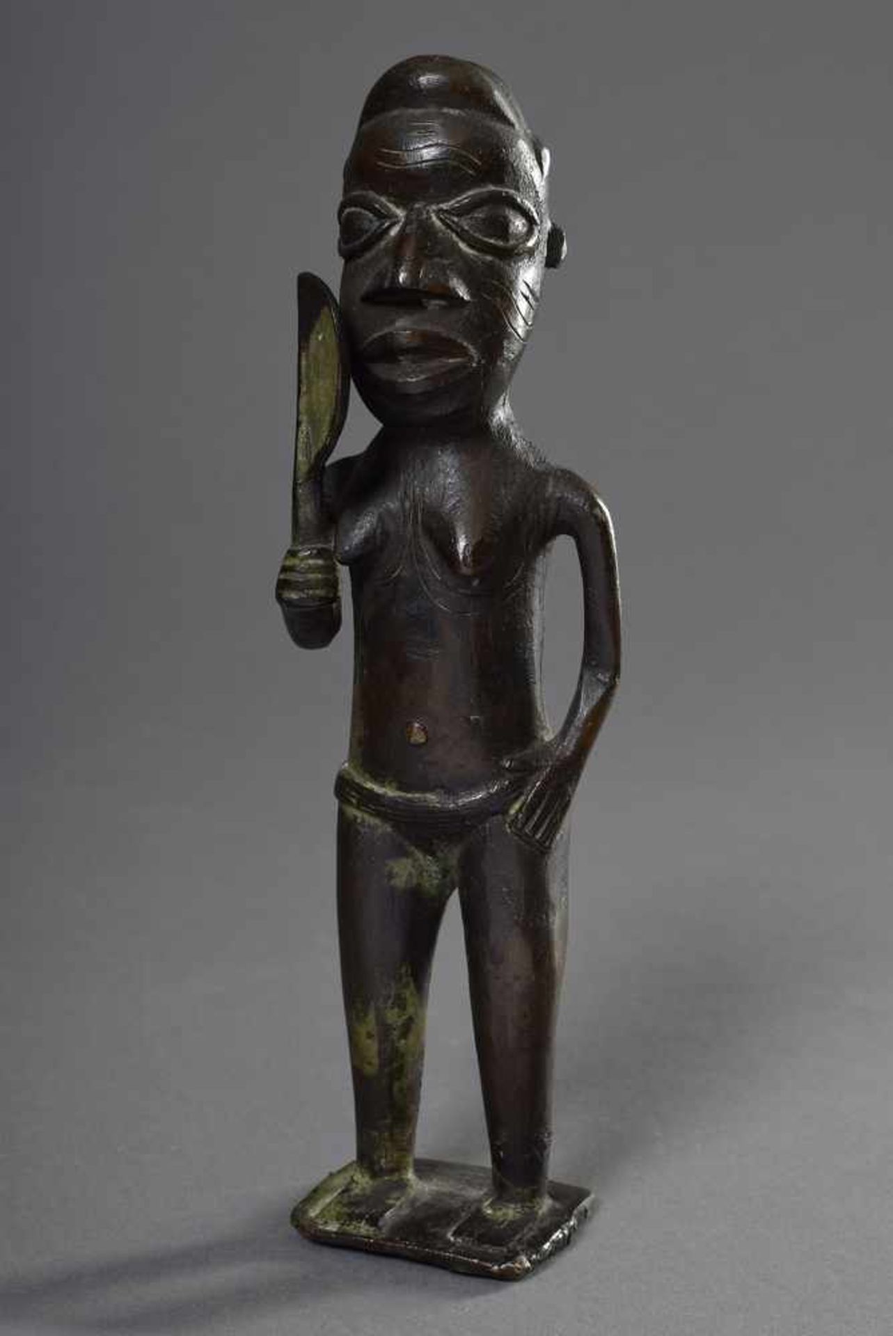 Stehende weibliche Yoruba Figur mit Fächer und Lendengürtel, Tatauierungen auf Stirn, Wangen und