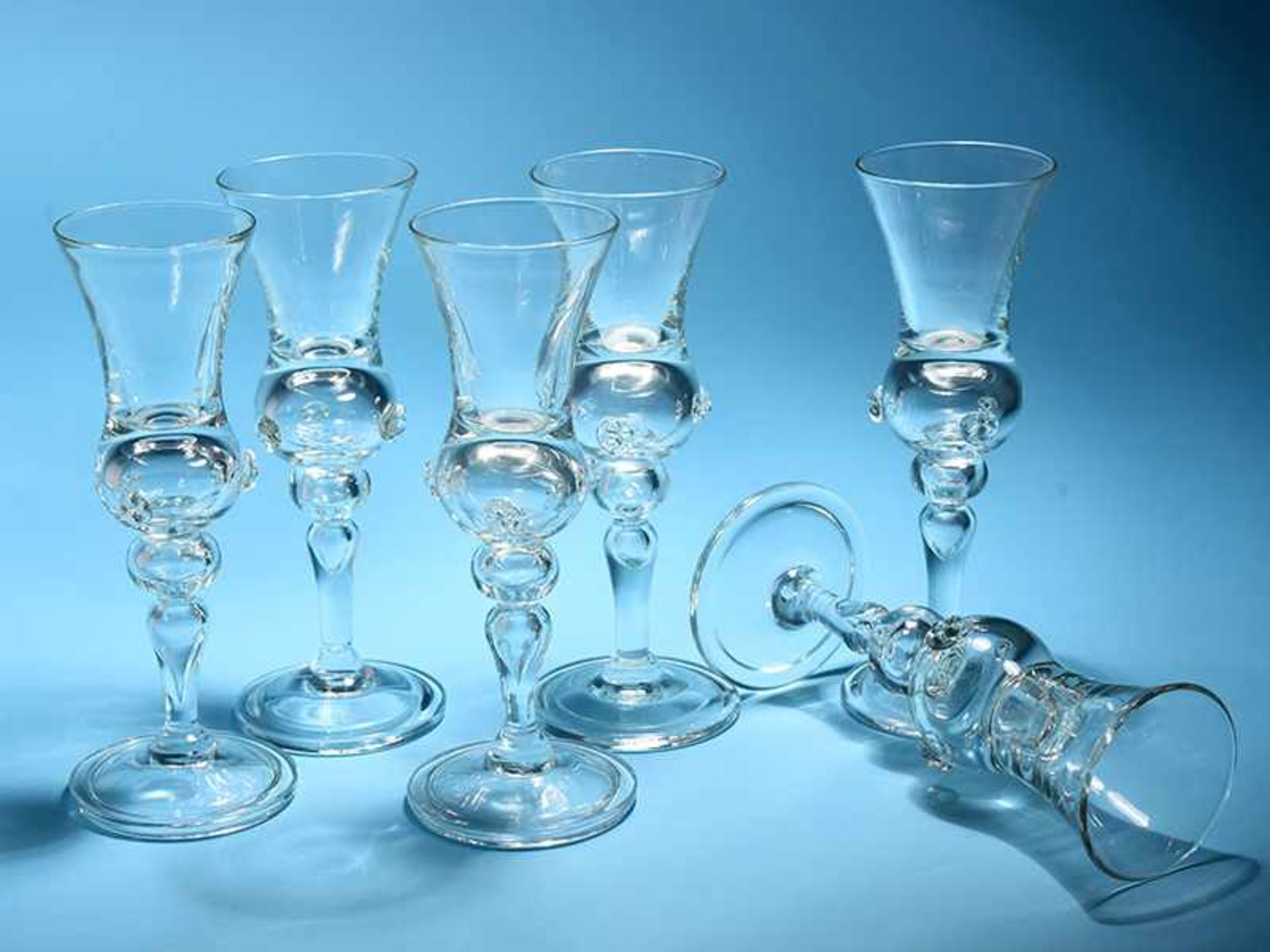 Sechs Gläser, im Stil des 19. Jh. Farbloses Glas mit aufgelegter Ornamentik. Scheibenfuß mit