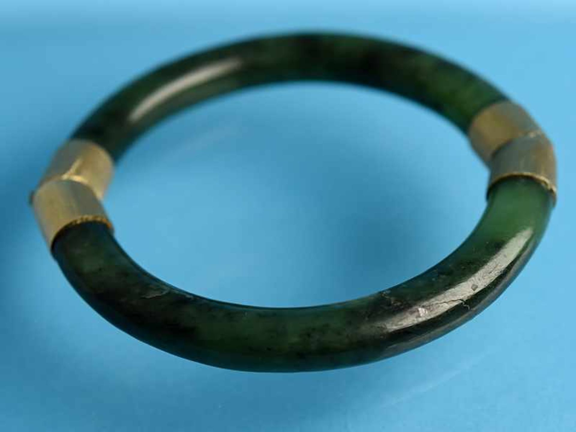 Armreifen aus Jade, 20. Jh. 585/- Gelbgold (geprüft). Zwei Halbbögen aus dunkelgrüner Jade mit