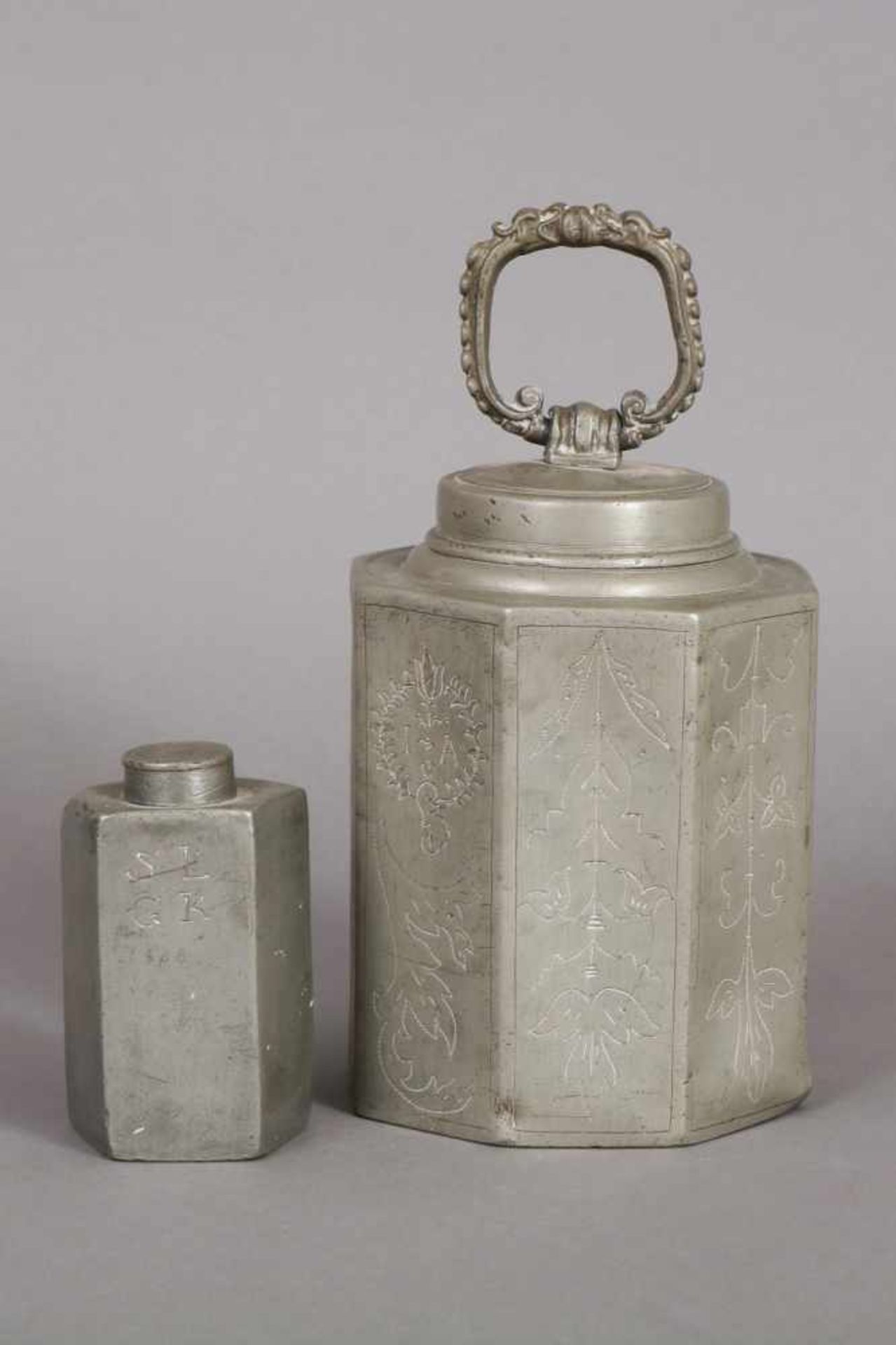 Paar Zinn-Schraubflaschen 1x oktogonale Form mit beweglichem Bügelgriff und ziseliertem