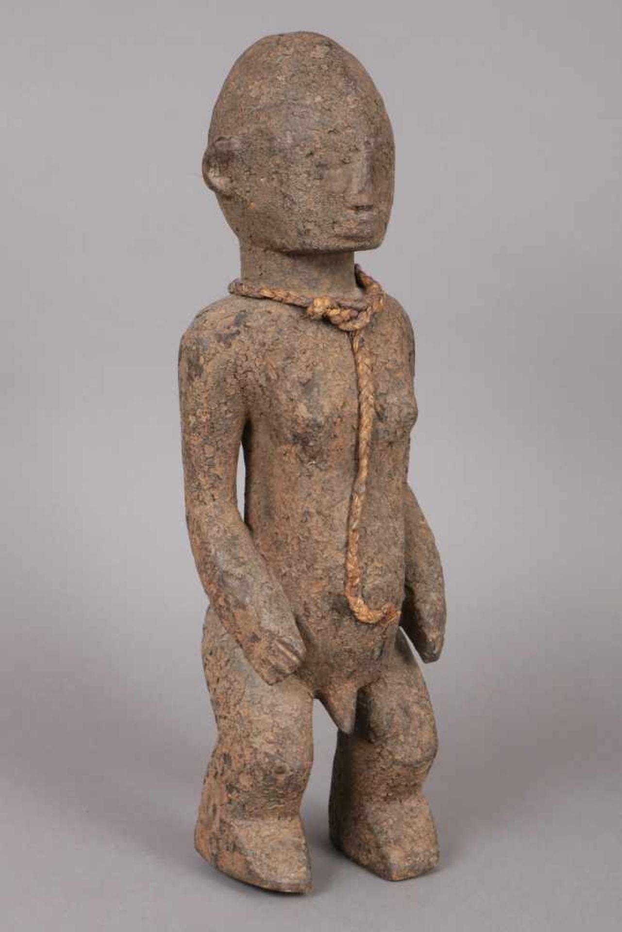 Ritualfigur der Songye Holz, geschnitzt, mit Lehm patiniert, wohl frühes 20. Jhdt., um den Hals eine