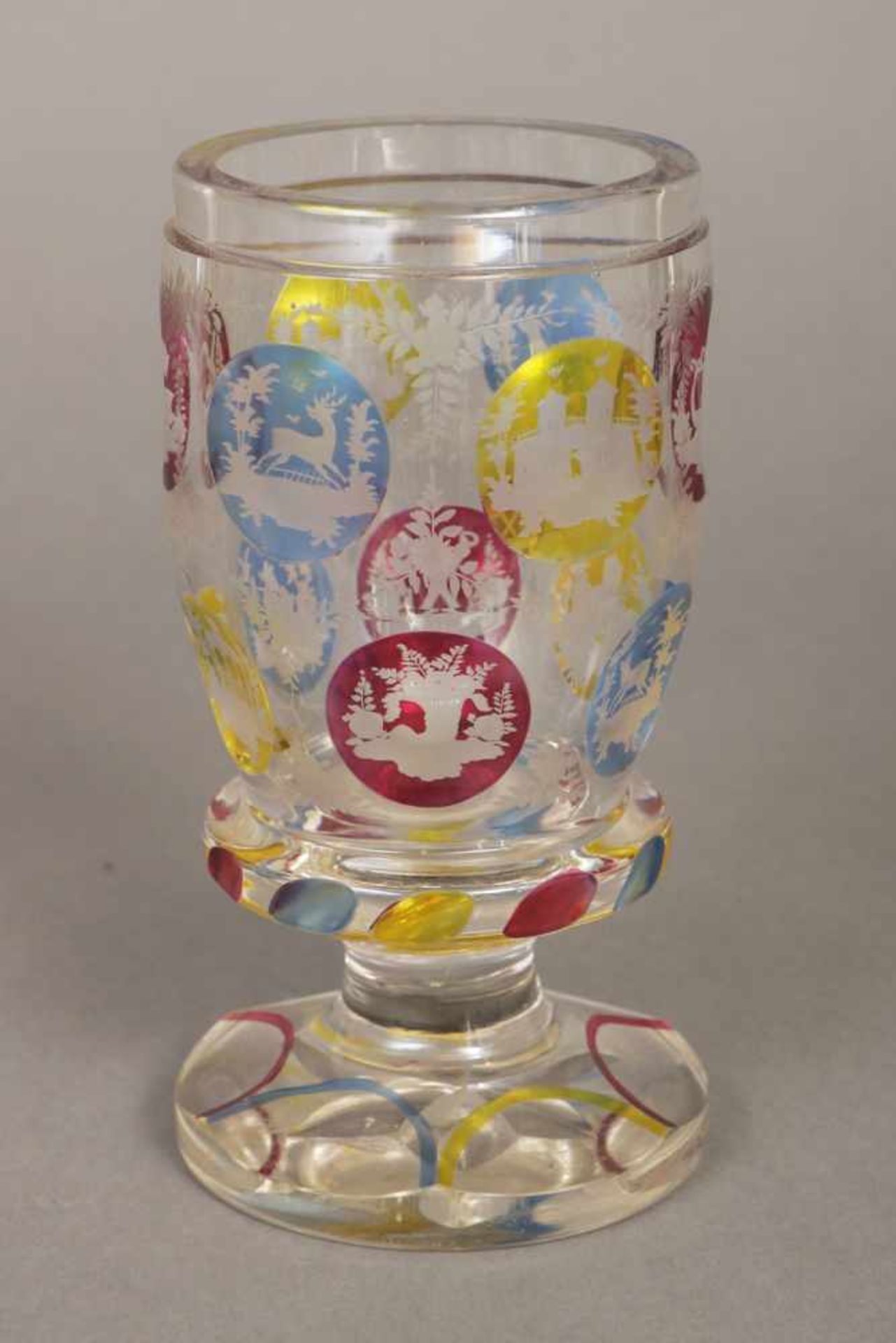 Böhmisches Fußglas farbloses Glas mit runden, farbig getönten Reserven mit diversen Motiven und