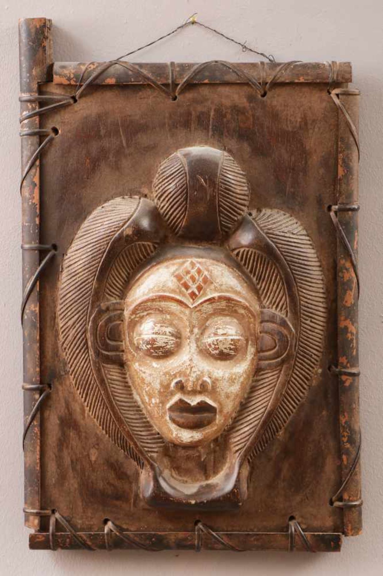 Afrikanisches Fenster/Fensterladen wohl Makonde, Holz, geschnitzt, mit Maskendekor, umflochten, hell