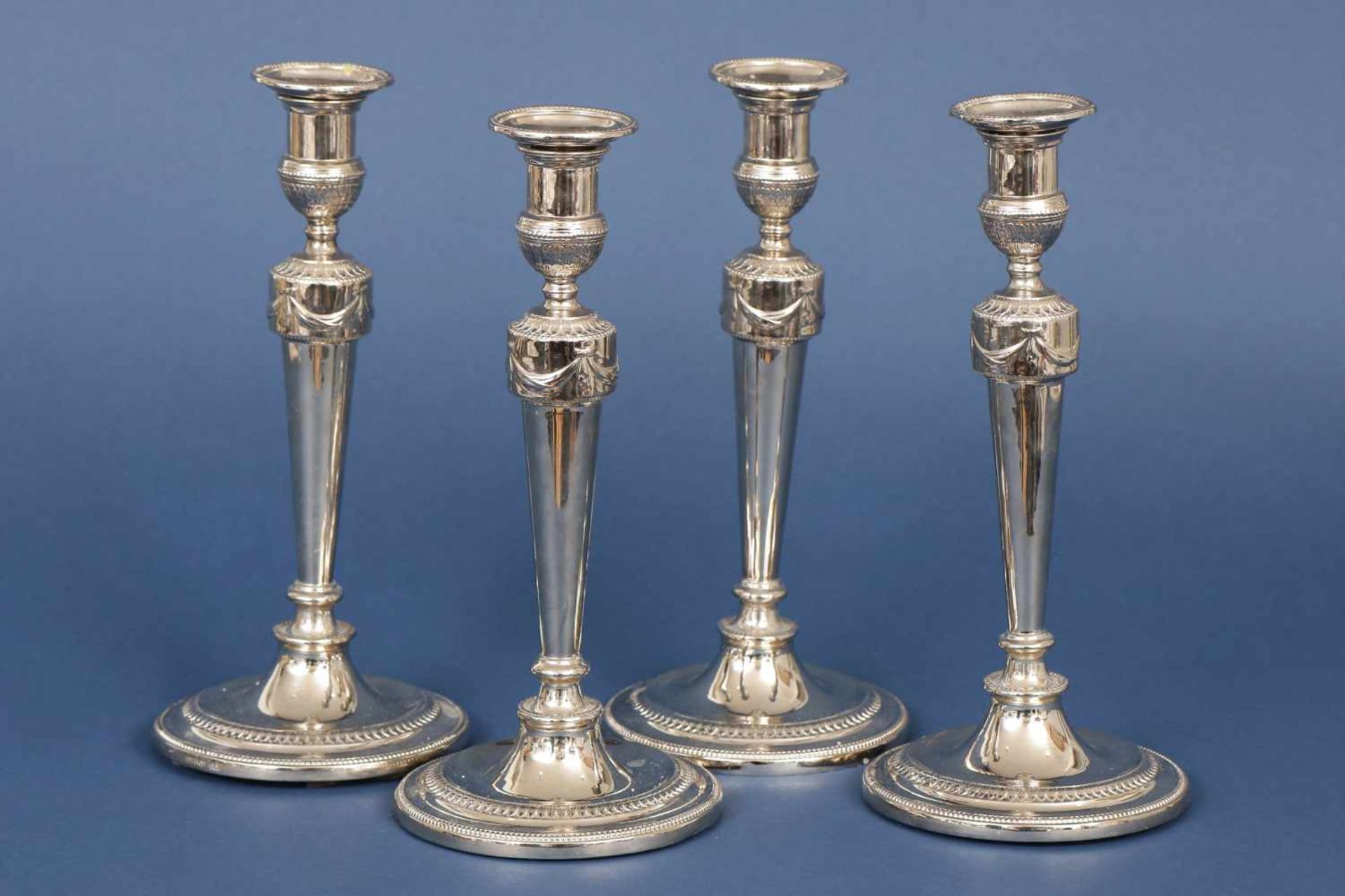 4 Kerzenleuchter im Stile des EmpireMetall, versilbert, mit Girlanden-, Perl- und Blätterdekor,