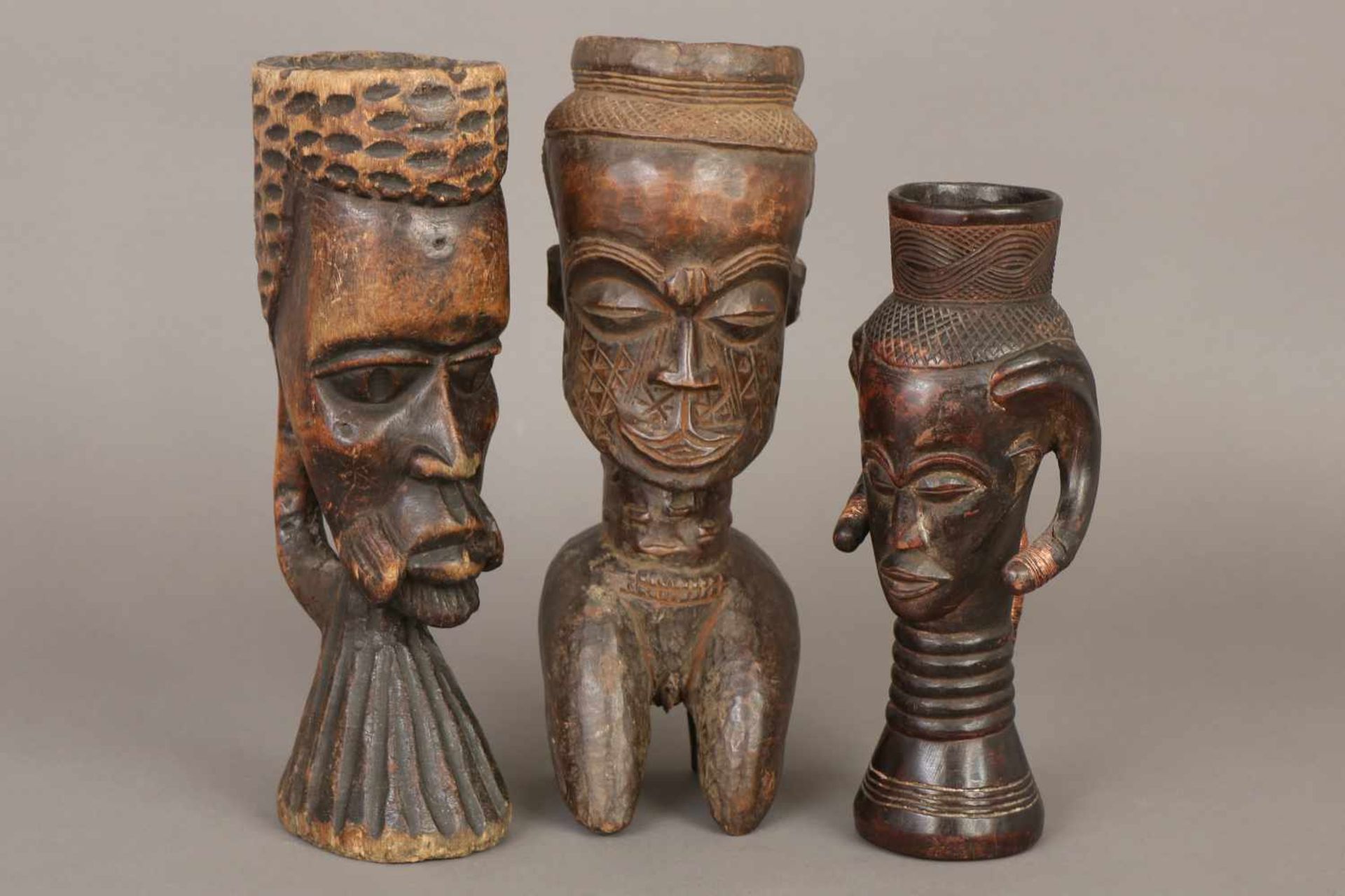 3 afrikanische Holzschnitzfiguren/Kräutergefäße der Kubain Form von Ahnenköpfen, dunkel patiniert,
