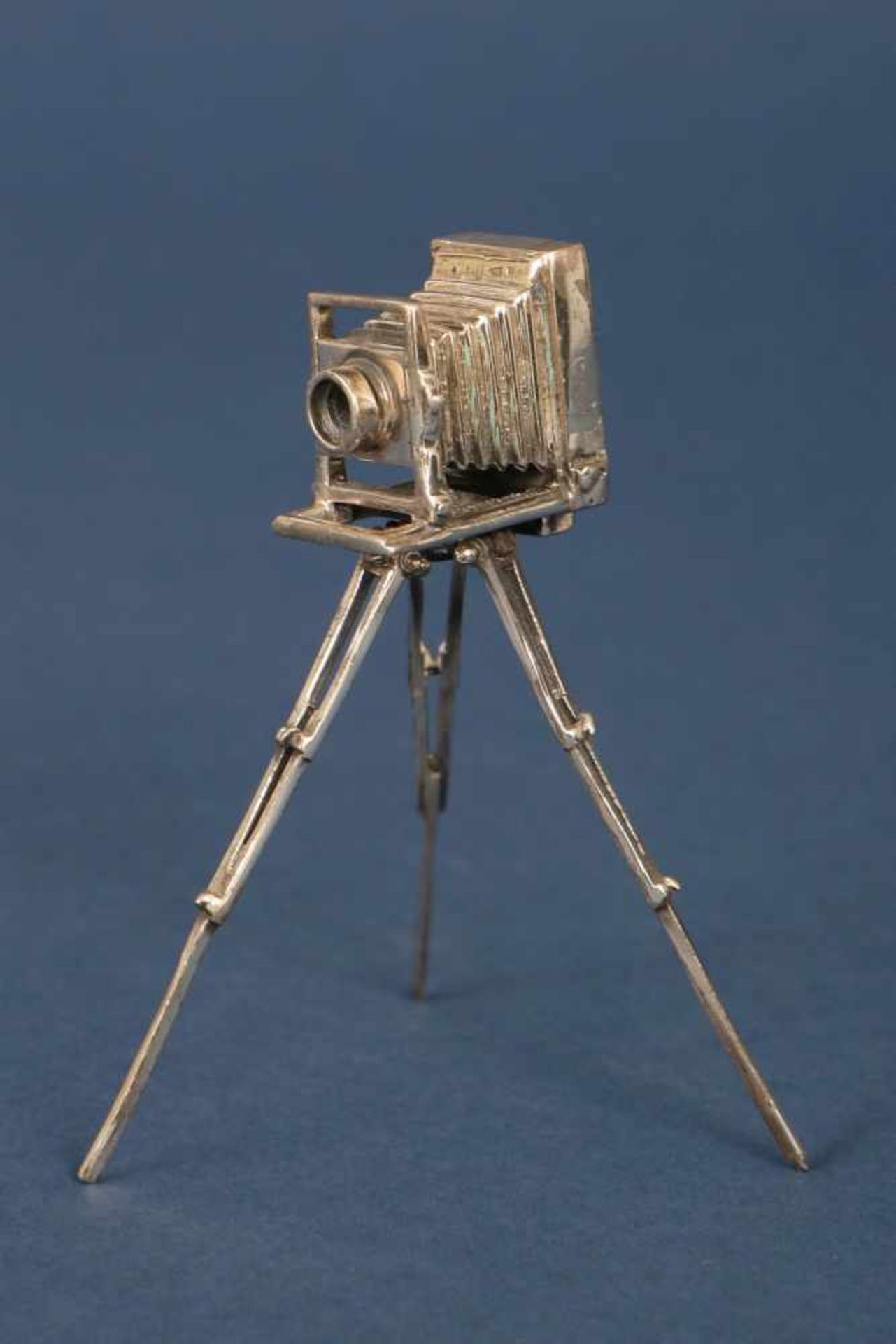 Modell einer alten Rollbodenkamera des 19. Jhdts.versilbertes Metall, auf 3-beinigem Stativ, H ca.