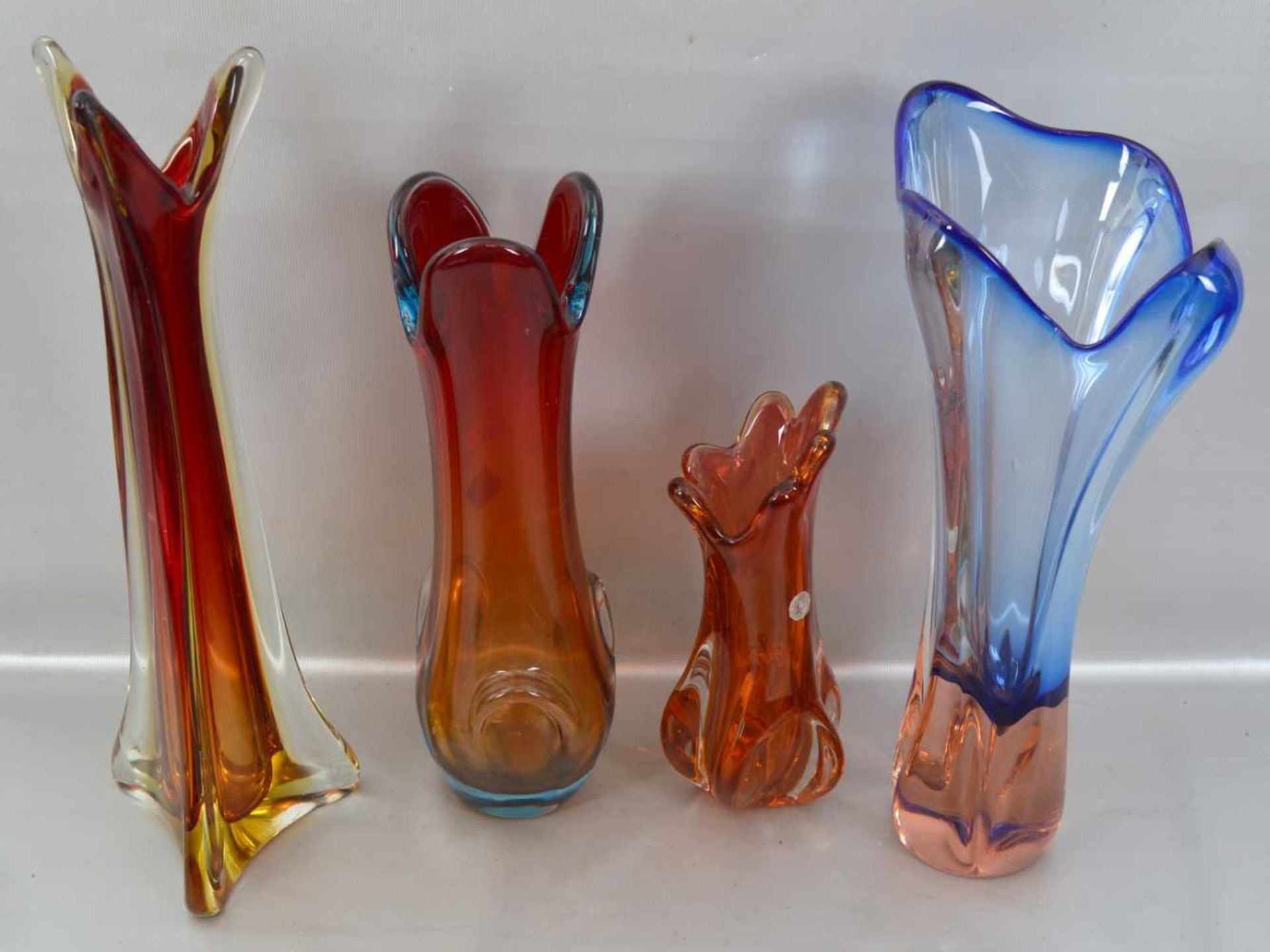 Konvolut vier Vasen farbl. Glas, teilweise mit buntem Überfang, unregelmäßig gezogener Rand,
