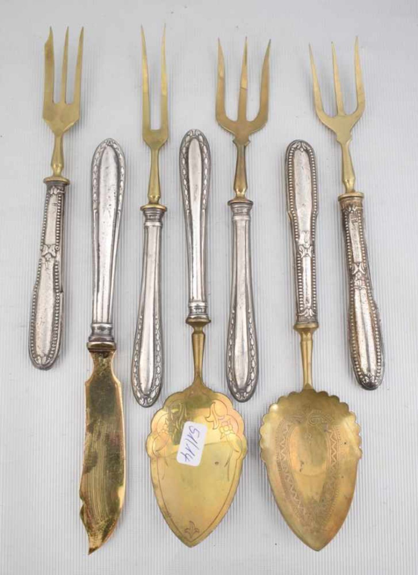 Sieben Vorlegeteile verschiedene Ausführungen, Messing, vergoldet, Griff 800er Silber
