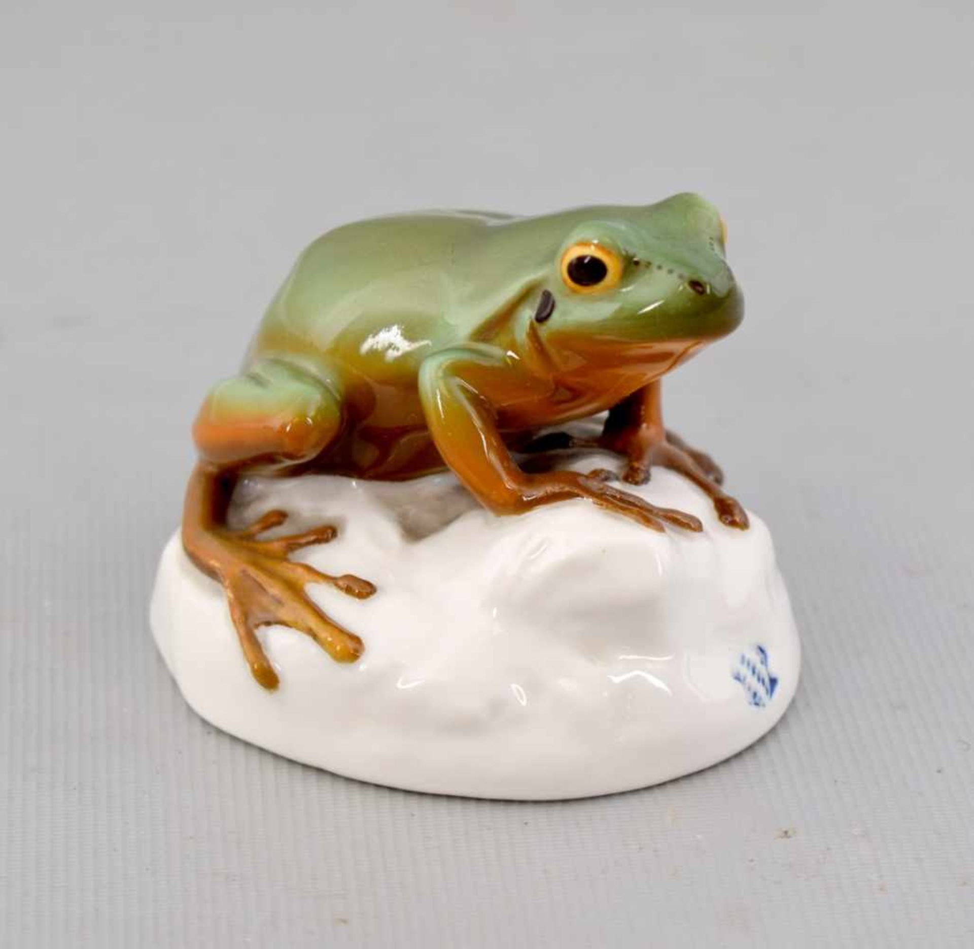 Frosch auf Stein sitzend, bunt bemalt, im Sockel monogr. JP, H 5 cm, L 6 cm, FM Nymphenburg