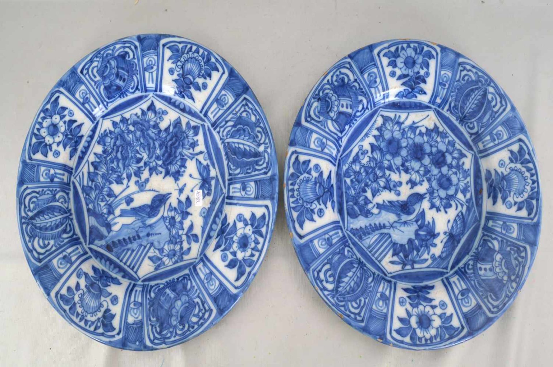 Zwei Teller Porzellan, beige glasiert, Rand und Spiegel blau bemalt, mit Blumenranken, Blüten und