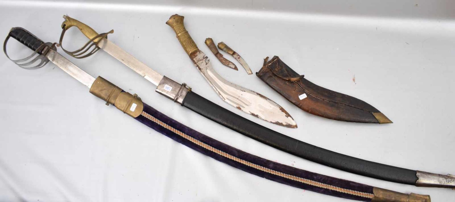 Konvolut zwei Säbel und ein MesserLeder- bzw. Stoffscheide, verschiedene Ausführungen und Größen