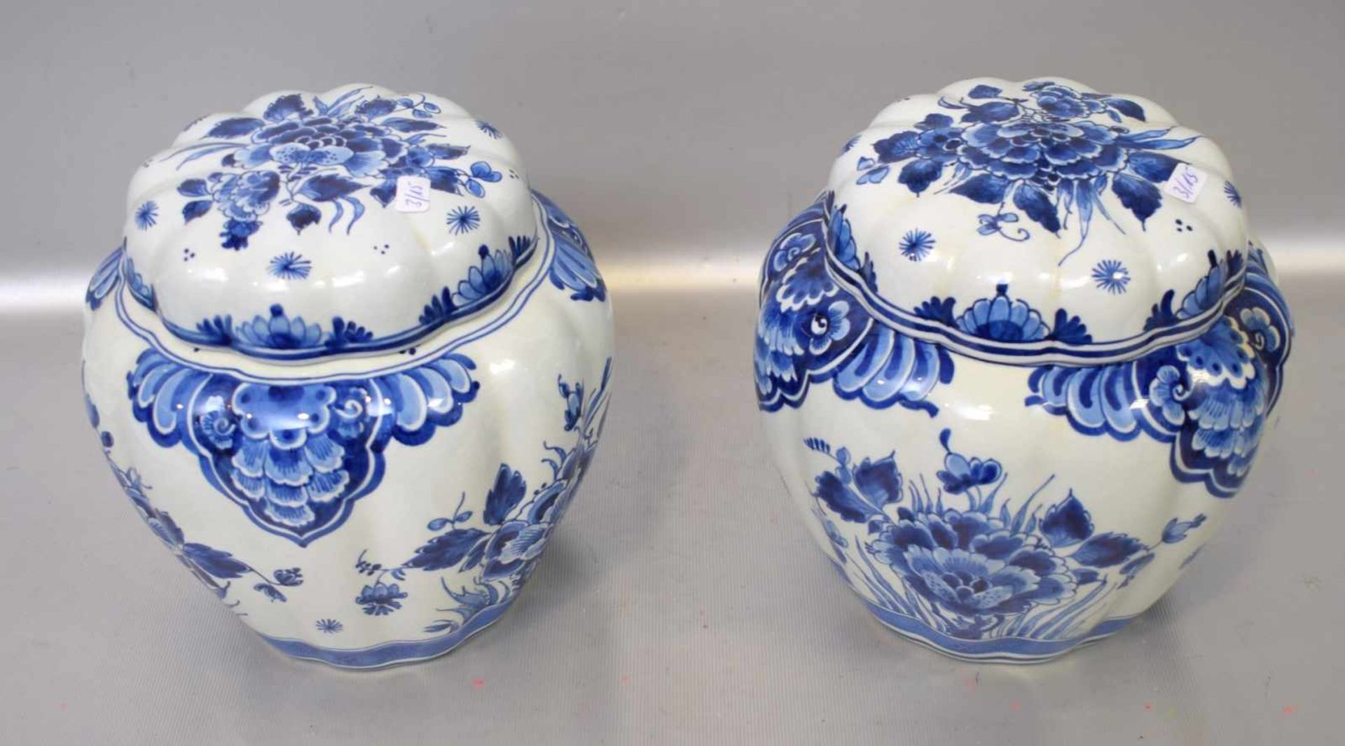 Zwei Deckeldosenbeigefarben, rund, gewellt, mit blauer Blumenbemalung, H 18 cm, Dm 17 cm, FM Delft