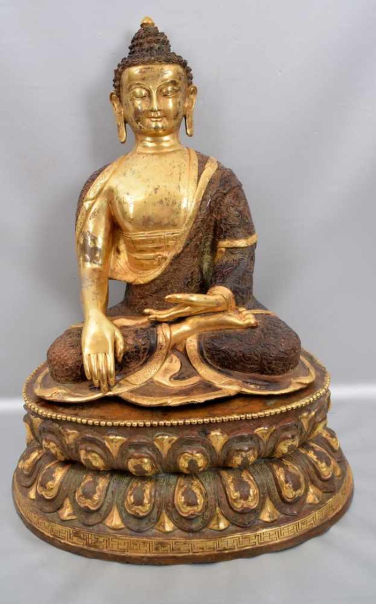 Sitzender BuddhaBronze, teilweise vergoldet, auf ovalem verzierten Sockel, abnehmbar, H 47 cm, B