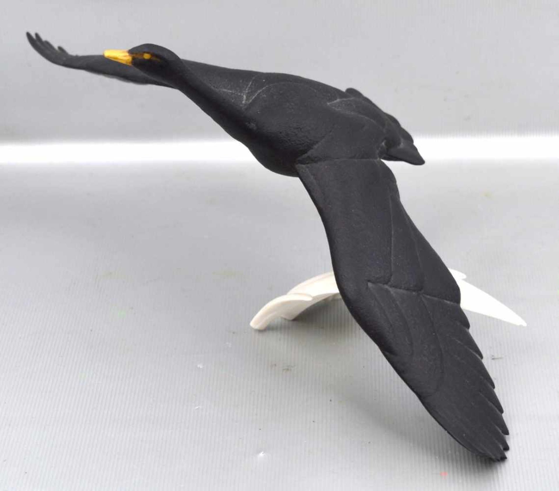 Der schwarze SchwanBiskuitporzellan, bunt bemalt, mit ausgebreiteten Flügeln, sign., H 12 cm, B 24