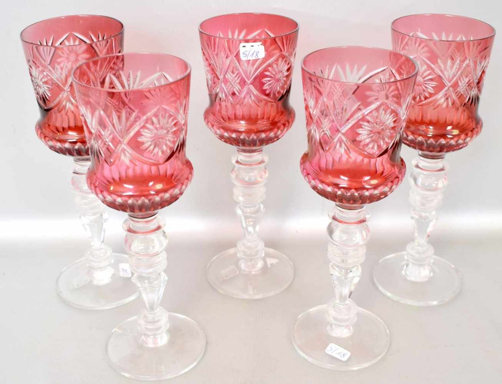 Fünf Weingläserfarbl. Glas, facettiert geschliffen, mit rotem Überfang, H 23 cm