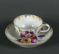 Tasse (Meissen, um 1800) mit UT; polychromer Blütendekor; Ränder ziervergoldet; UT mit leichtem