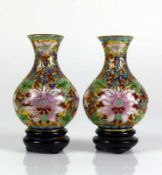 Paar kleine Cloisonné-Vasen jeweils farbiger Blütendekor; jeweils auf Holzsockel; H: je 8 cm (ohne