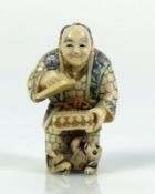 Netsuke (Japan, um 1900) "Stehender Mann"; in den Händen eine geöffnete Dose haltend; darunter