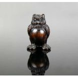 Netsuke (Japan, um 1900) "Sitzender Uhu"; dunkles Holz geschnitzt mit signierter Elfenbeineinlage;