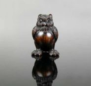 Netsuke (Japan, um 1900) "Sitzender Uhu"; dunkles Holz geschnitzt mit signierter Elfenbeineinlage;