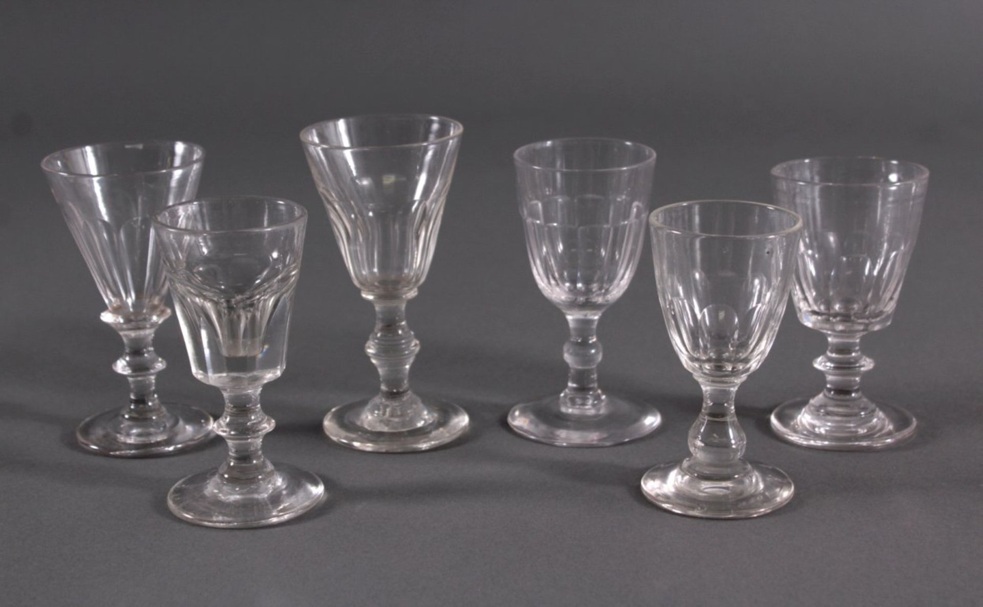 Sechs Gläser, 19. Jh.Mundgeblasenes Klarglas, Scheibenfuß, kelchförmige Kuppa, imunteren Teil