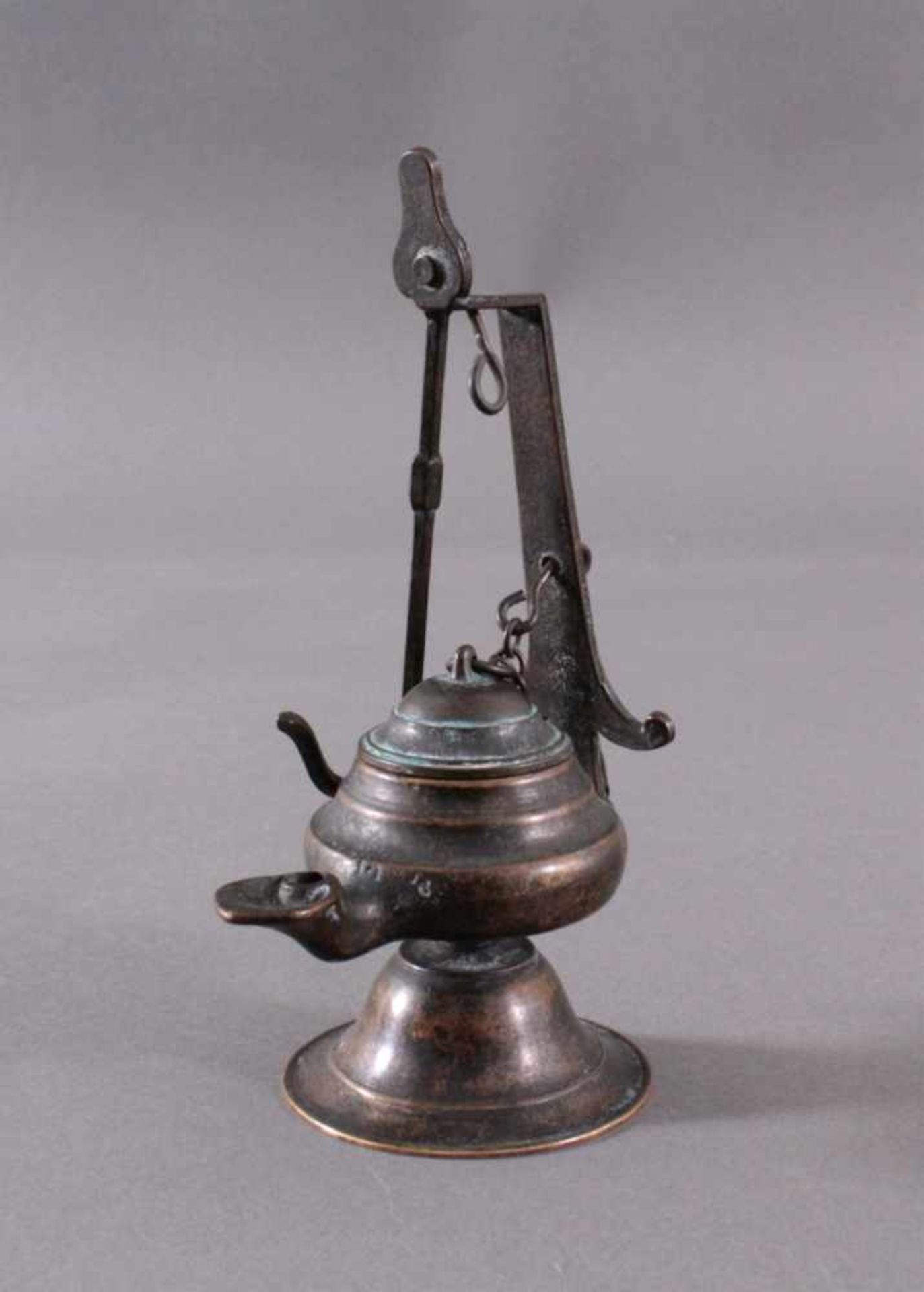 Bronze Öllampe, 19. Jh.Bronze, dunkel patiniert, mit Dochttülle und Halterung zumAufhängen. Höhe mit