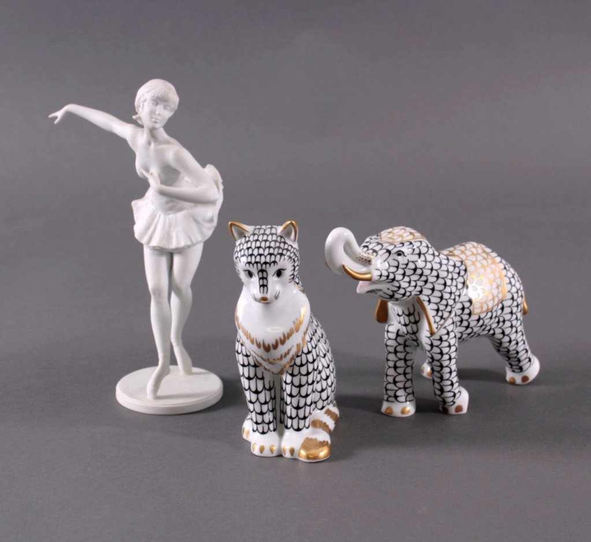 Drei Figuren KaiserporzellanPorzellan Elefant und Katze sind weiß mit Schwarz- undGoldbemalung.