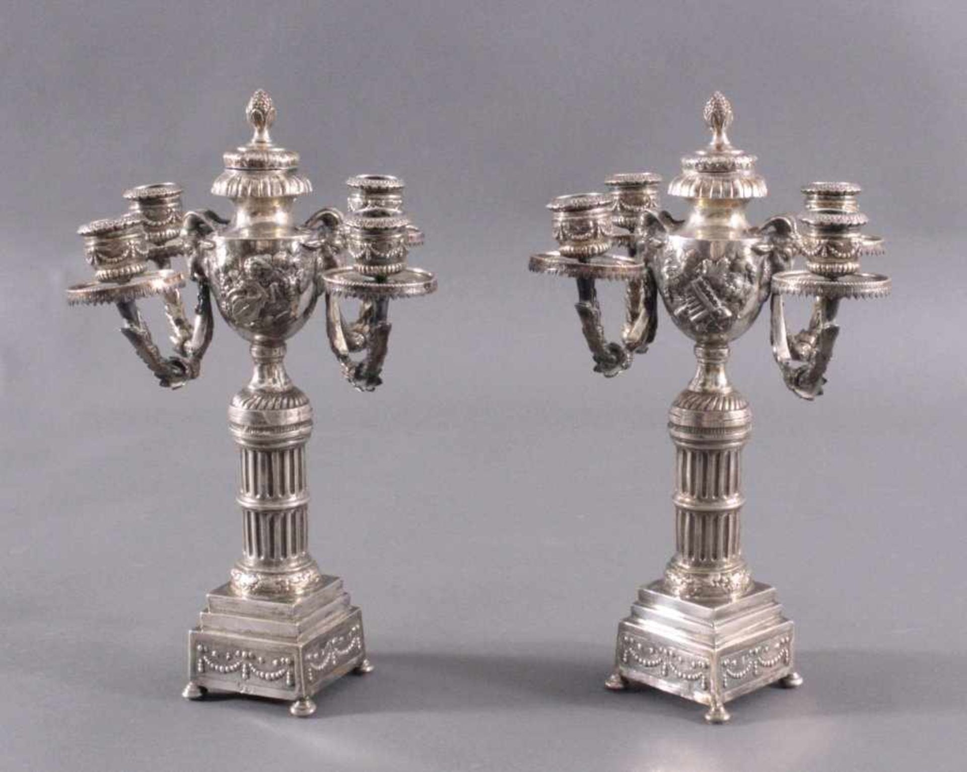 Paar silberne Empire KerzenleuchterUm 1800, auf viereckigen Sockel, getragen von vier rundenFüßen.