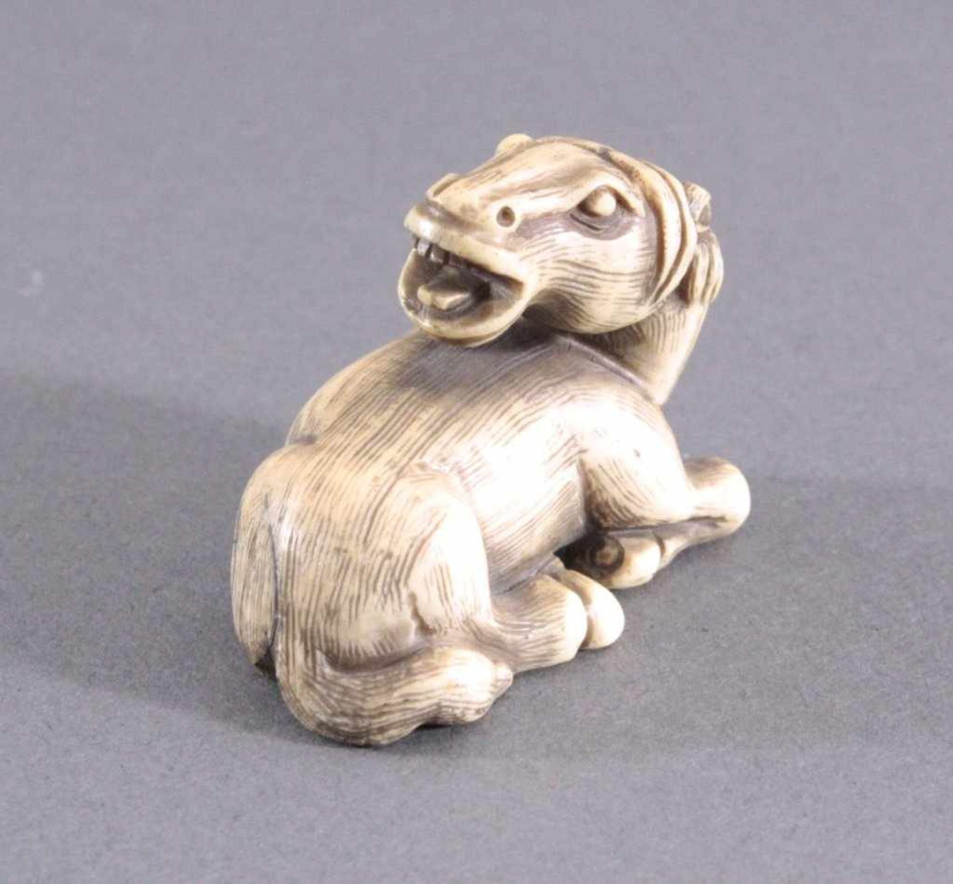 Netsuke, Japan 1. Hälfte 20. Jh., Elfenbein geschnitztVollplastische Schnitzerei, liegendes Pferd,