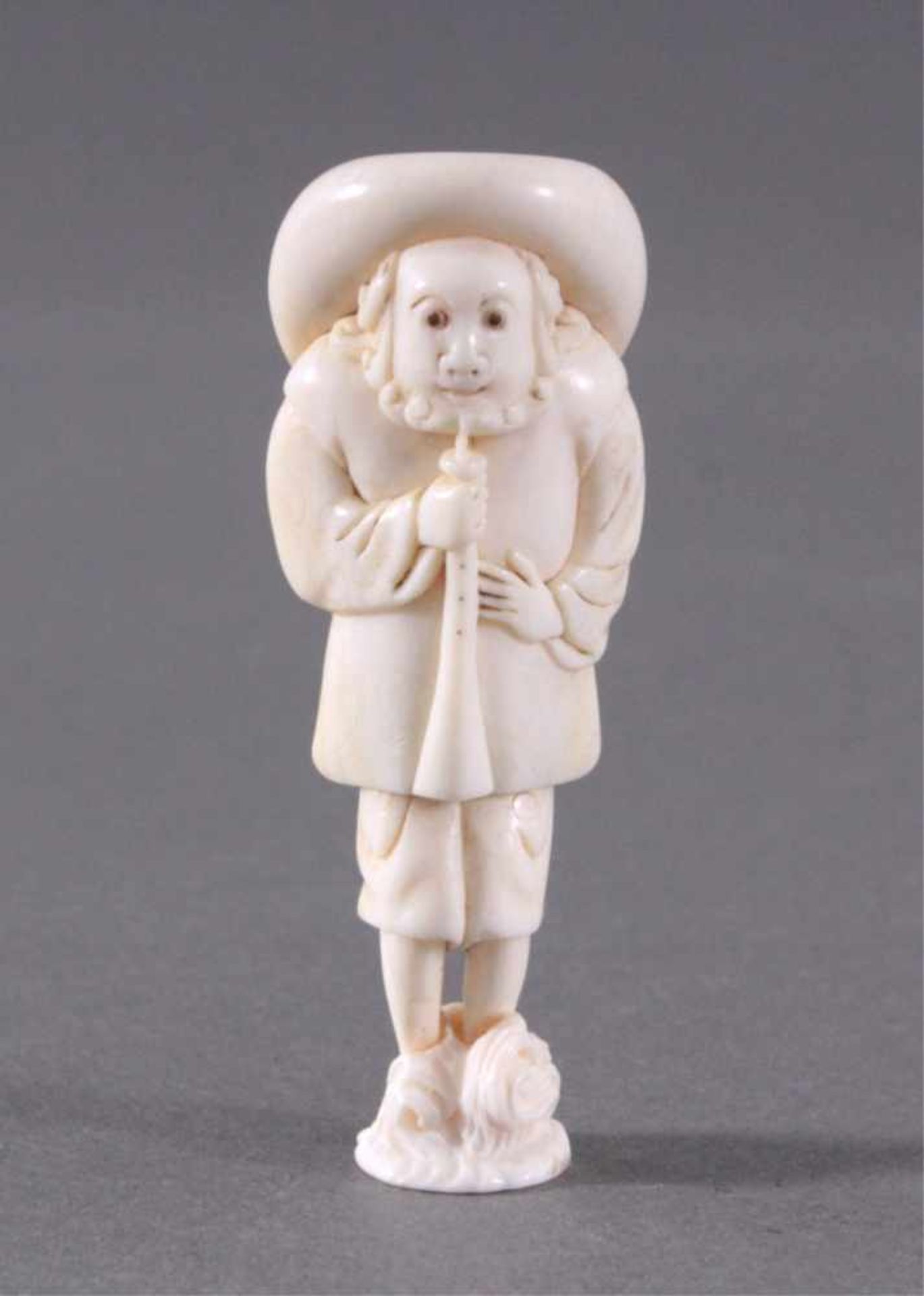 Netsuke, Japan 1. Hälfte 20. Jh., Elfenbein geschnitztStehender Mann mit Stoch und Hut,ca. 6,9 x 2,5