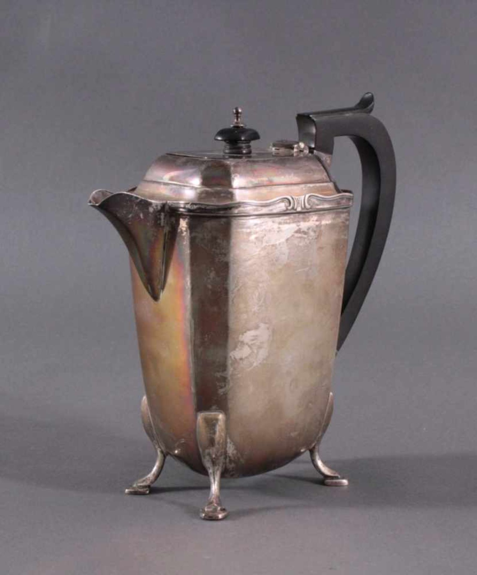 Silberne Teekanne, England 19. Jh.Silberne Kanne auf vier Volutenfüßen, ebonisierter Griff undKnauf,