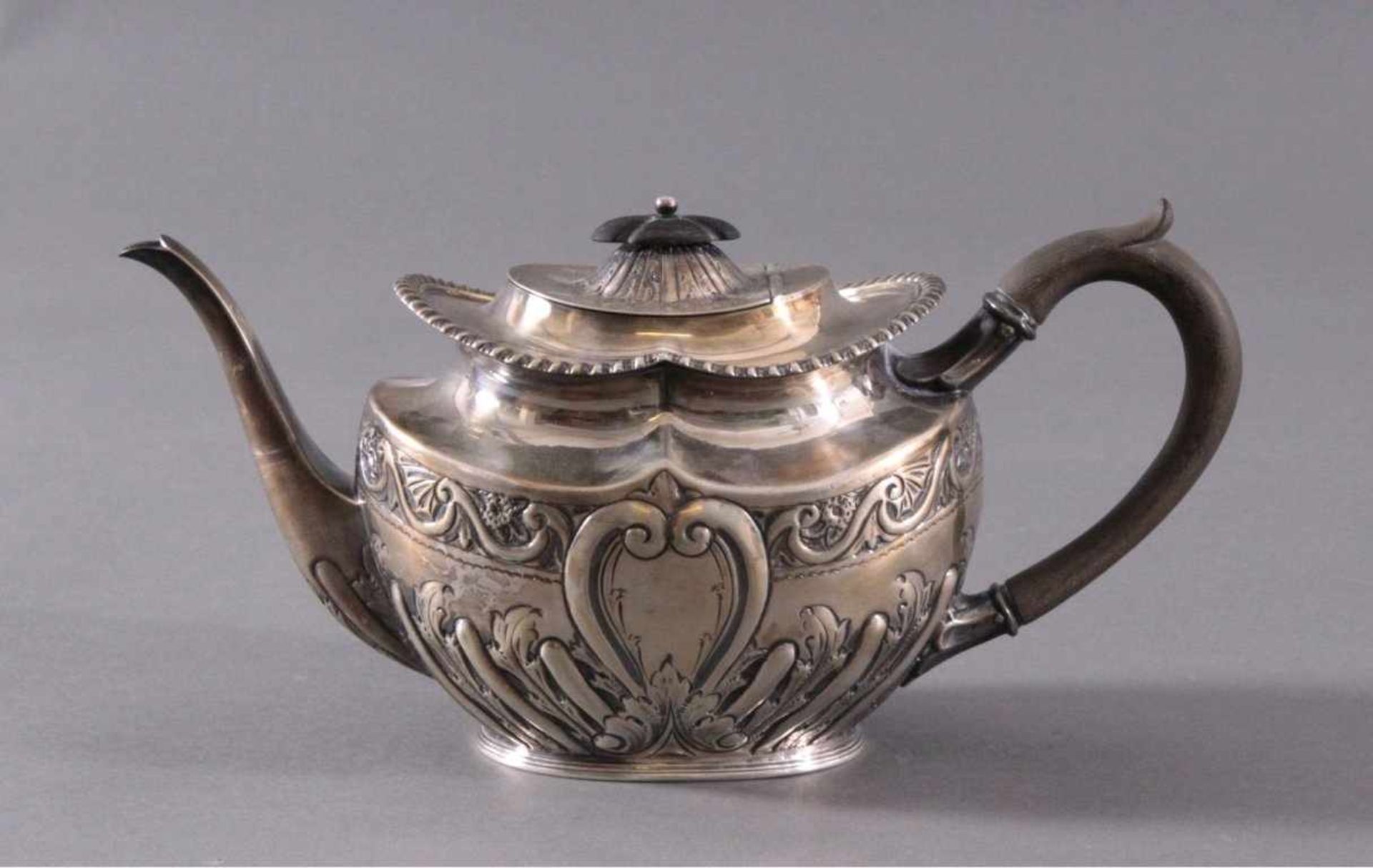 Silberne Teekanne, England 19. Jh.Getriebenes Silber, reliefierte Wandung, ebonisierter Griffund