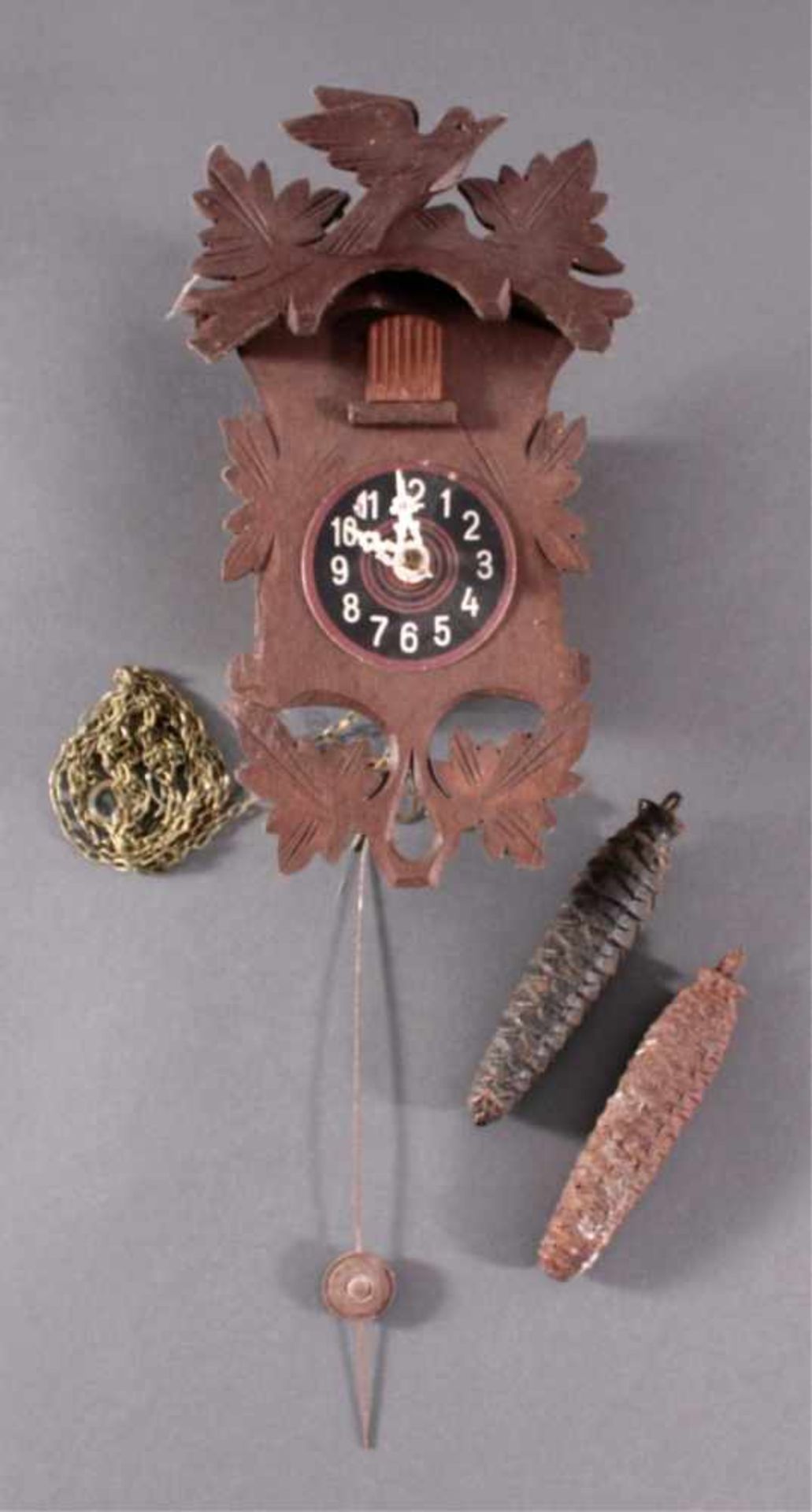 Kleine Schwarzwalduhr um 19002-gewichtig, mit Pendel. Geschnitztes Holzgehäuse, arabischeZiffern.
