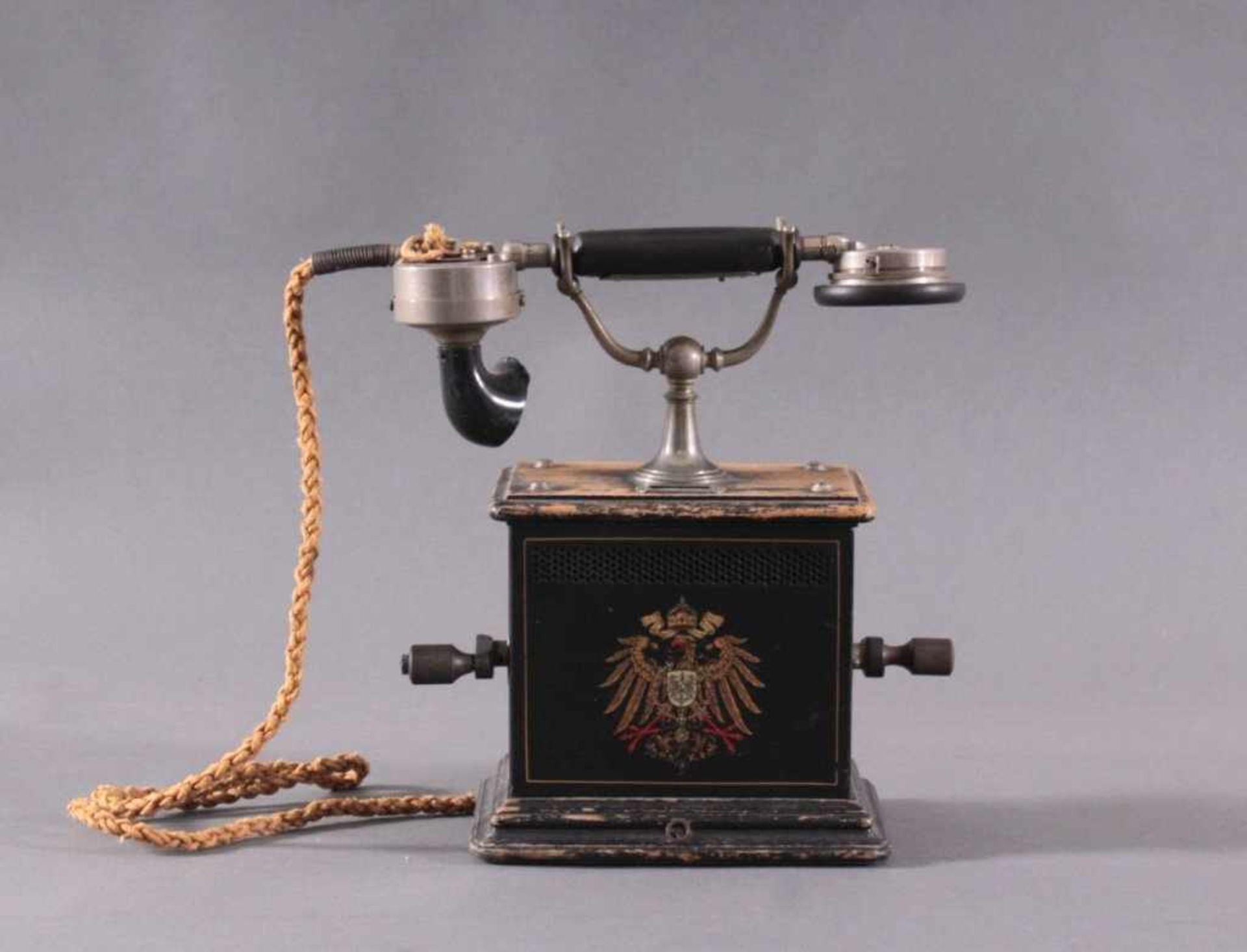 Kurbeltelefon um 1900Eisen / ebonisiertes Holzgehäuse. Auf der Schauseite mitpolychrom bemalten