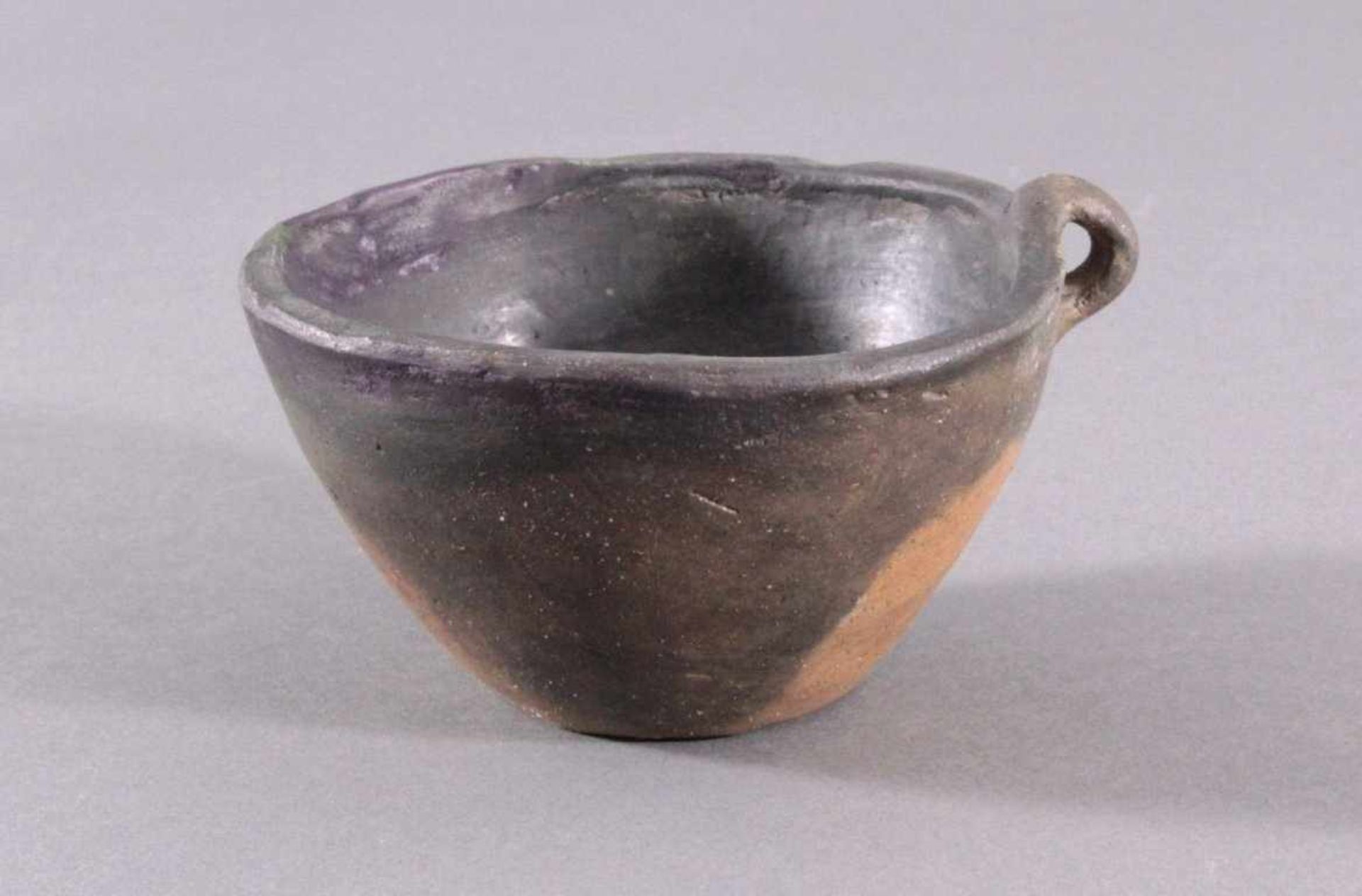 Henkelgefäß - Lausitzer Kultur 900-500 v. Chr.Tassenförmiges Einhenkelgefäß, aus dunkelbraunem Ton,