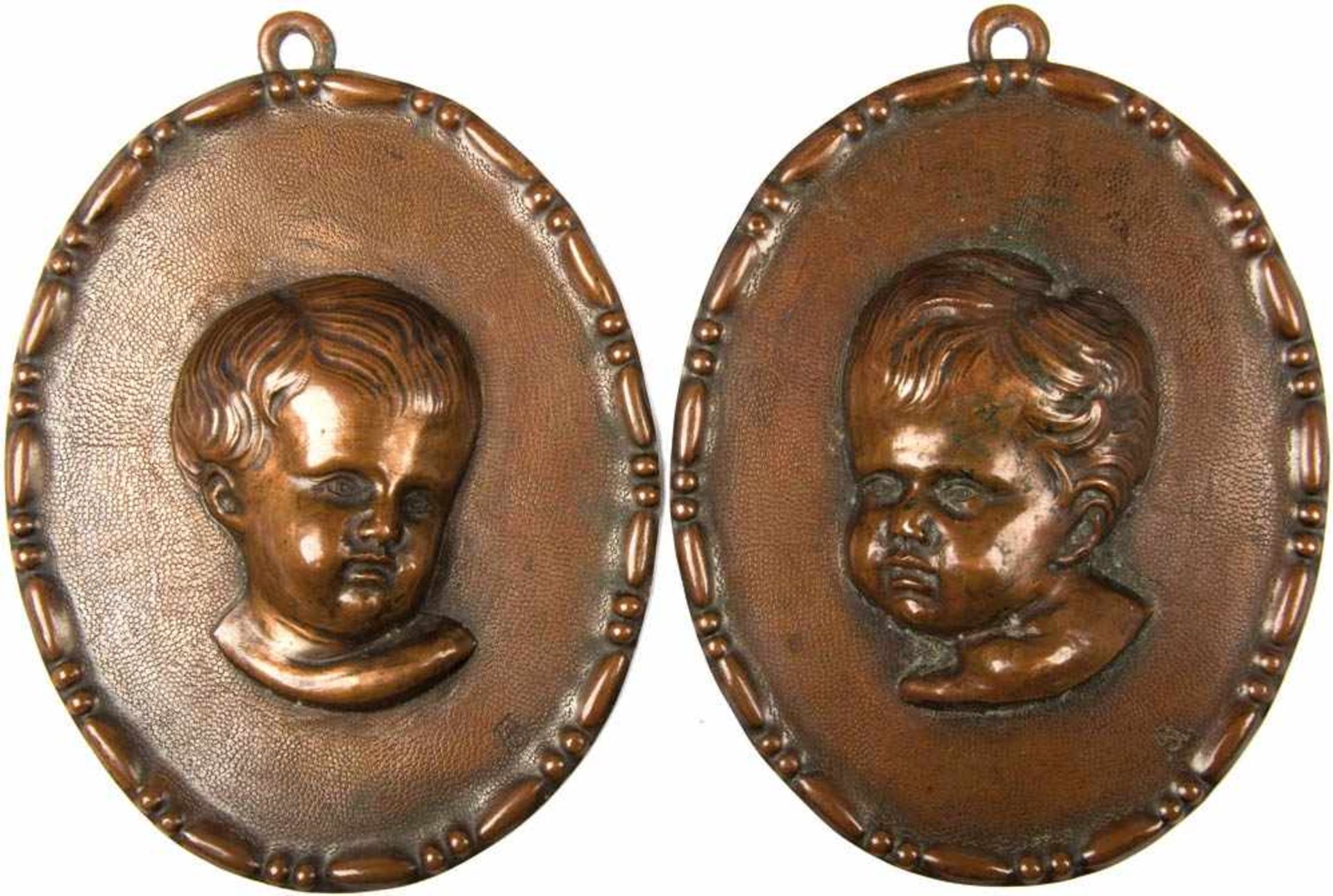 2 RELIEF-PORTRAITS, getriebenes Kupfer, Büsten v. Putten, sign. „AS“, oval, 14x11 cm, um 1900