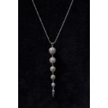 A Modernist Design diamond set five ball tapering globular pendant necklace,