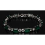 A diamond and emerald bracelet, ten graduating vibrant green emeralds ranging form approx 1.