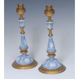 A pair of ormolu mounted Wedgwood jasperware candlesticks sprigged in white with Classical figures,