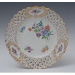 A Meissen shaped circular basket-weave plate, painted with colourful summer flower,