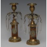 A pair of Regency brass mantel lustres, arching arms terminating in rose-capped faceted lustres,