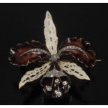 A diamond encrusted enamel orchid brooch, three creamy tapering petals,