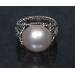 A half pearl solitaire ring, rope twist basket and indistinctly marked white metal shank, size L/M,